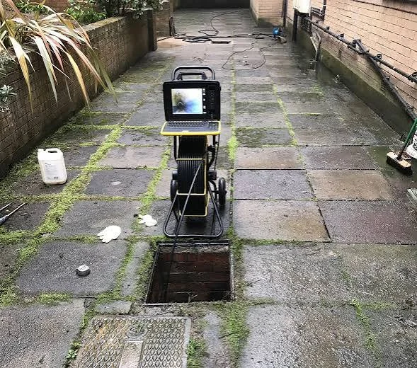 CCTV drain survey equipment positioned over an inspection chamber